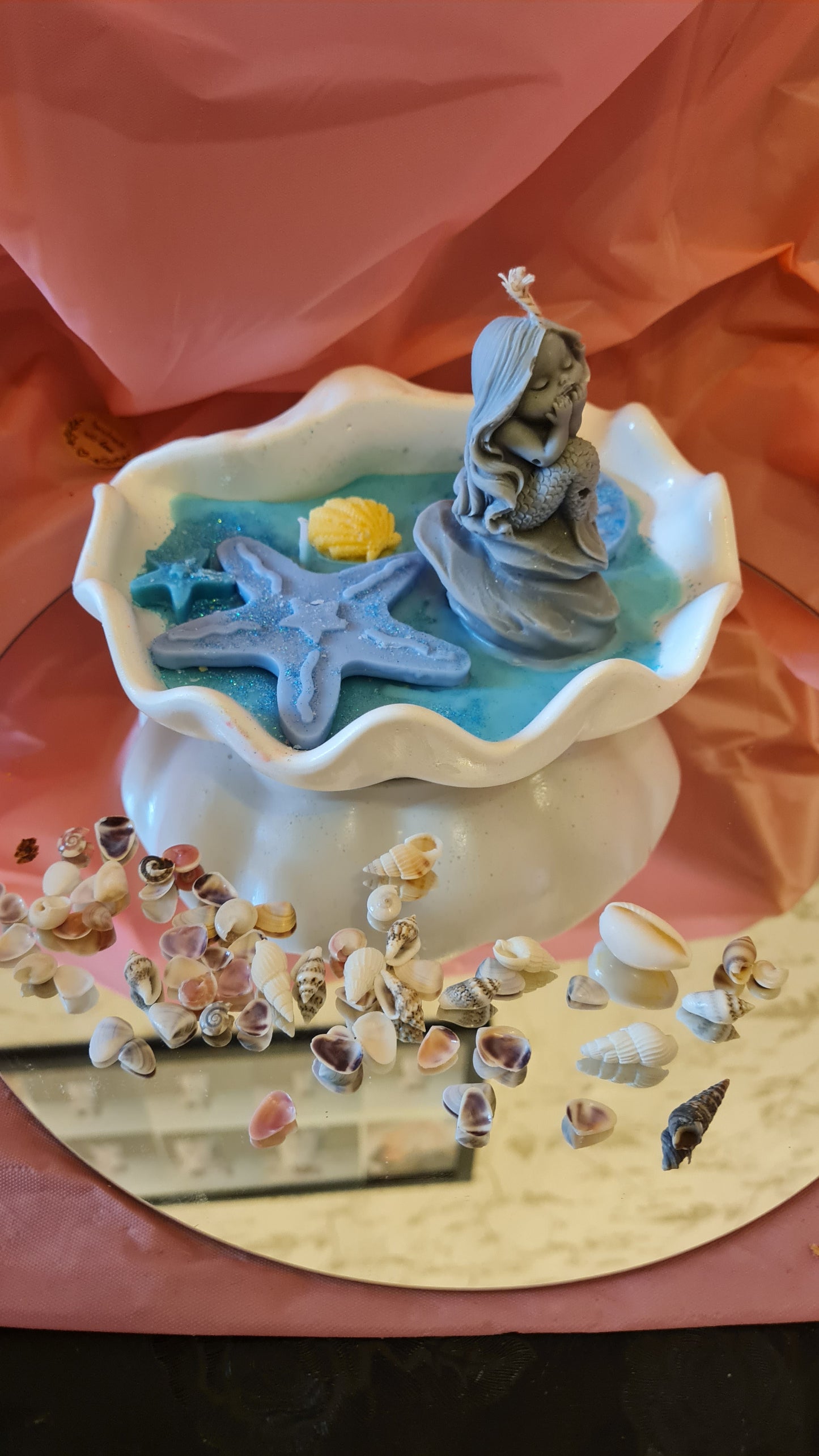 Clam filled with soy wax decorated with Starfish and a Mermaid on a rock.