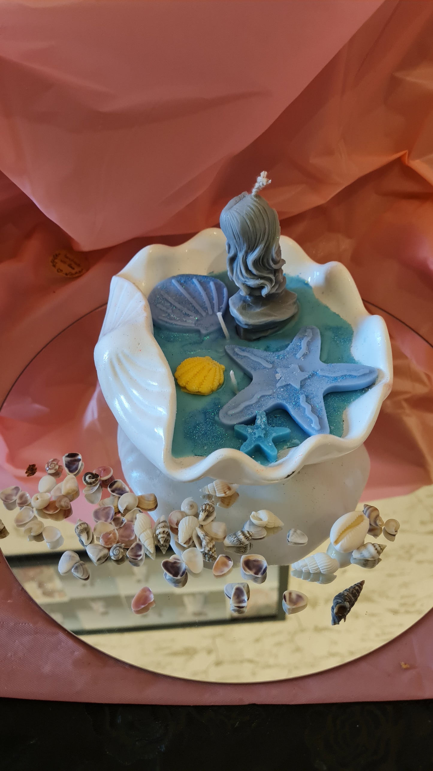 Clam filled with soy wax decorated with Starfish and a Mermaid on a rock.