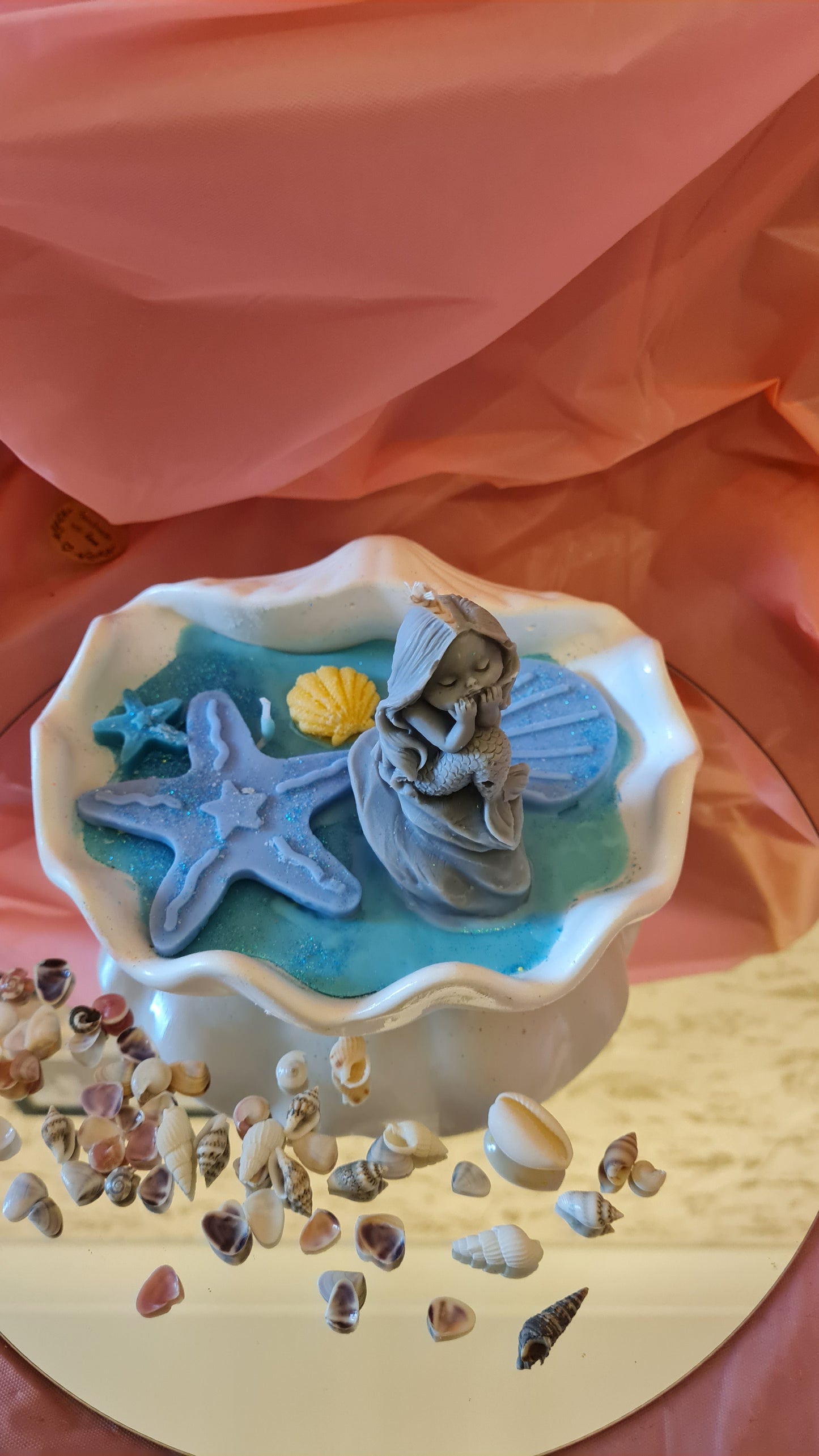 Clam filled with soy wax decorated with Starfish and a Mermaid on a rock.