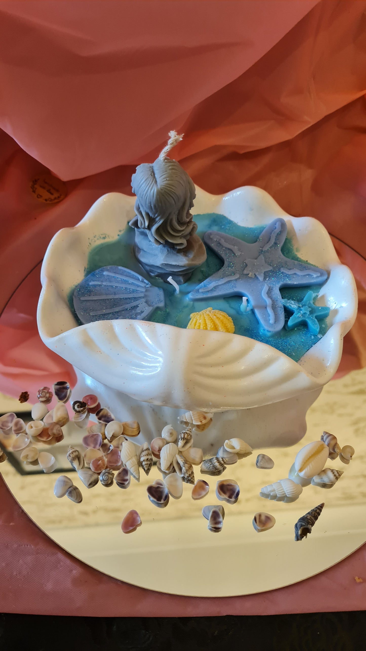 Clam filled with soy wax decorated with Starfish and a Mermaid on a rock.