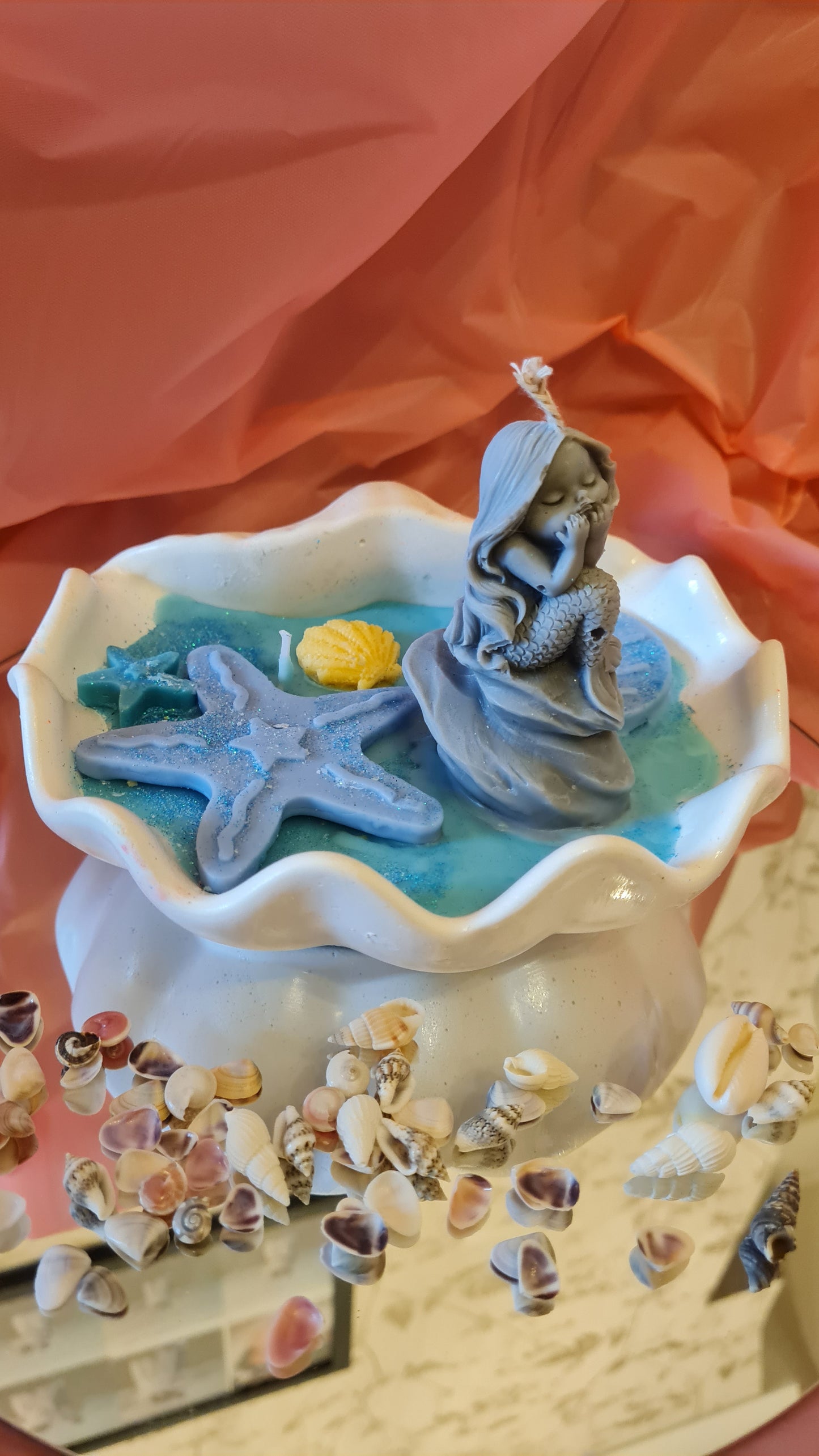 Clam filled with soy wax decorated with Starfish and a Mermaid on a rock.